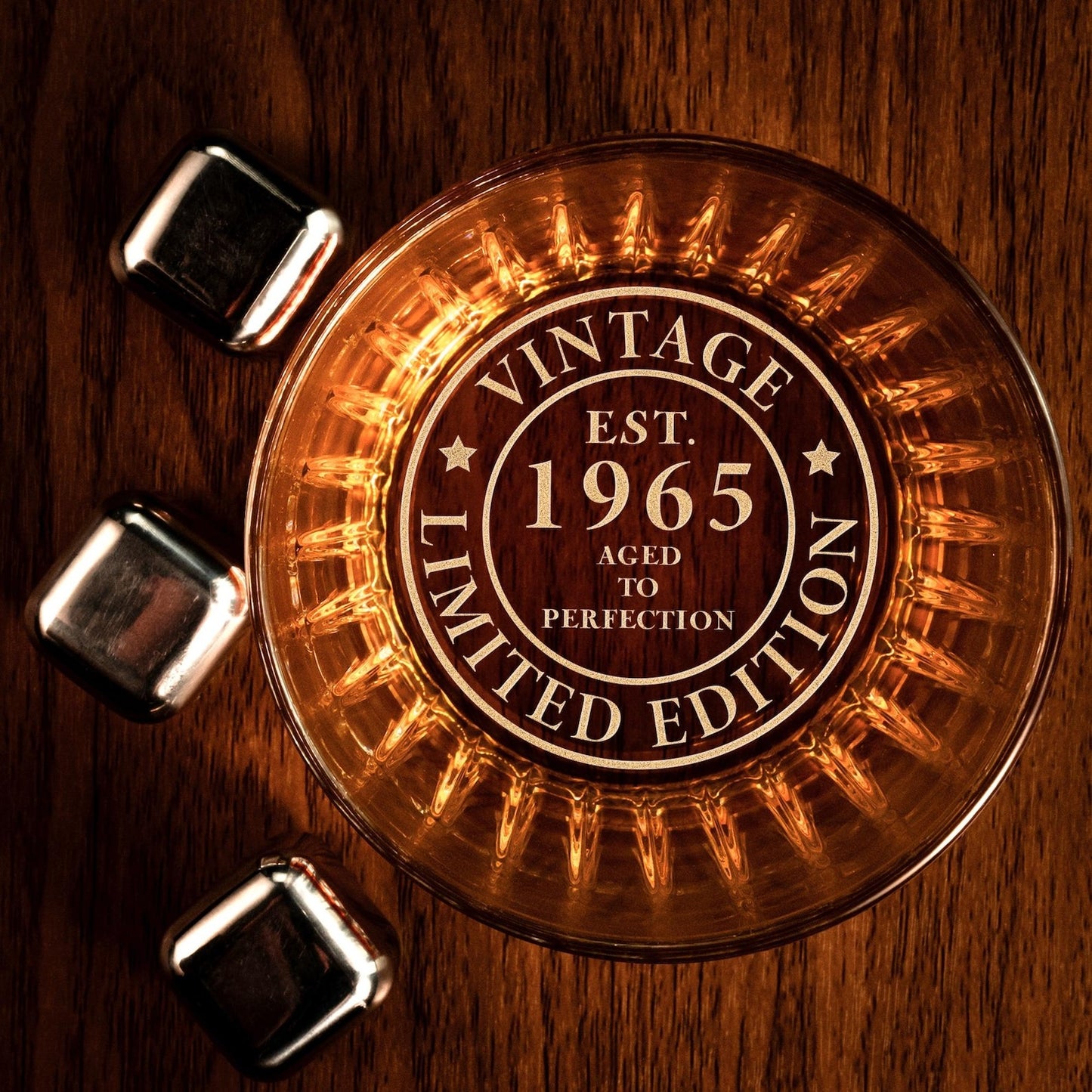 Custom whiskey glass engraved with 'Vintage 1965' and 'Limited Edition' with ice cubes.