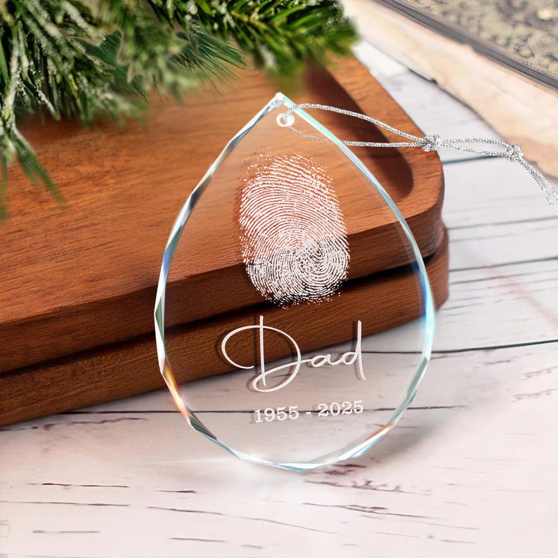 A beautiful memorial ornament, the Personalized Fingerprint Dad Remembrance Teardrop Glass Ornament features an engraved fingerprint.