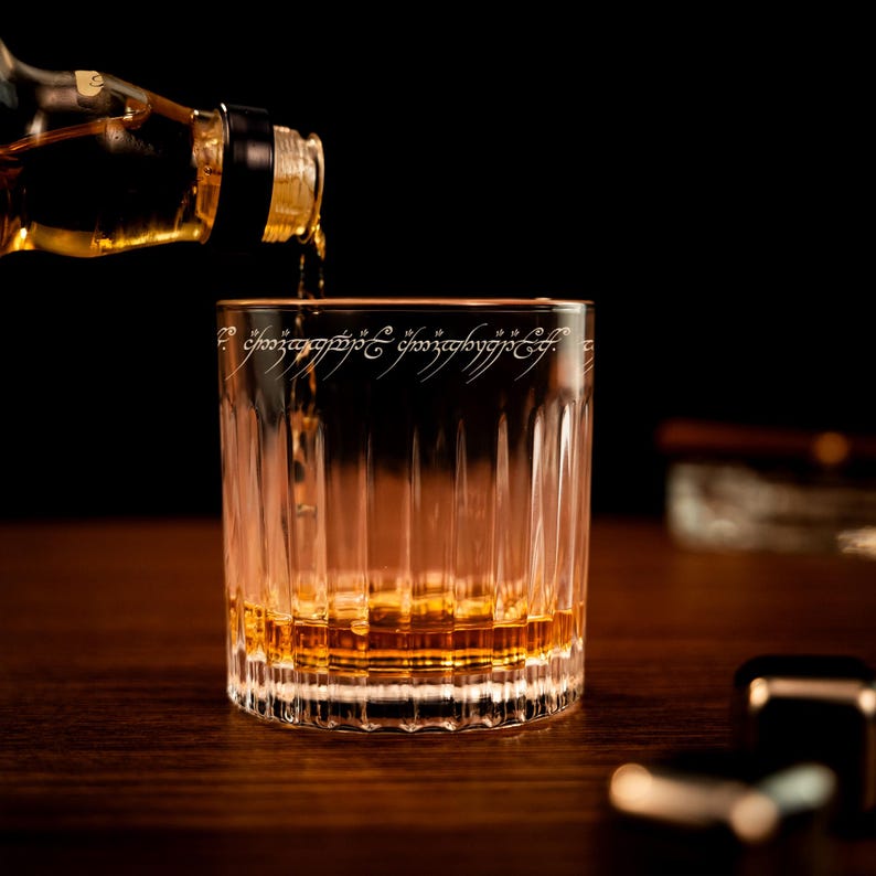 A close-up of an engraved custom whiskey glass, the Personalized Lord of The Rings Crystal Whiskey Glass is a great gift for him.