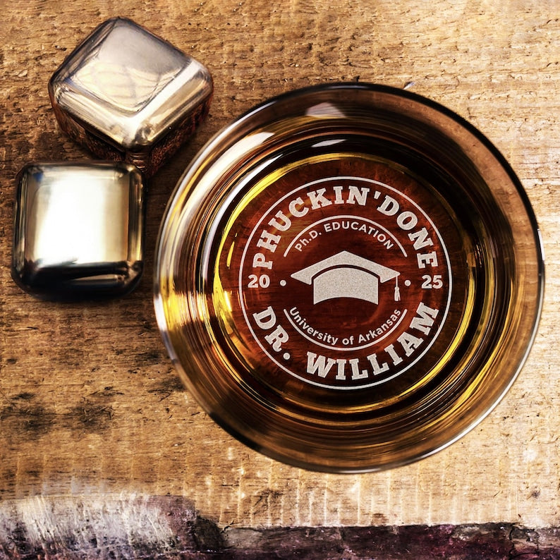 This custom whiskey glass features a humorous PhD design, making it one of the best college graduation gifts.